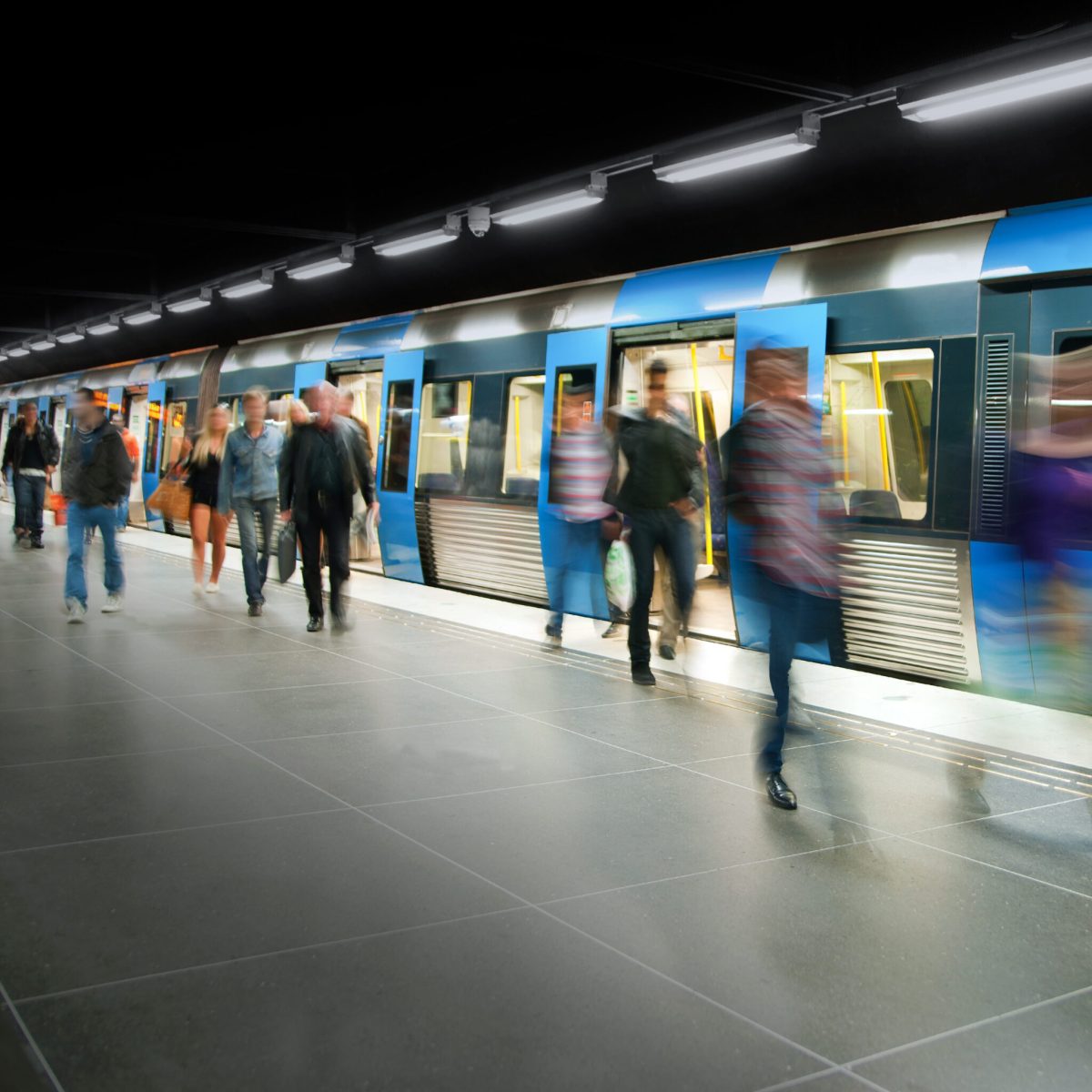 Blurred people on subway platform leaving the train